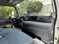 Interior view of a 2015 Mitsubishi Fuso FE160 featuring a dashboard with controls and a driver's seat positioned on the left side