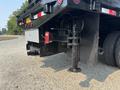 Close-up of the rear section of a 2009 Ford F-450 Super Duty featuring a hydraulic jack and towing equipment on a black truck body