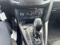 Close-up of the center console of a 2018 Ford Focus featuring the gear shifter climate controls and electric outlet