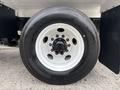 A close-up of a white wheel and tire from a 2025 Peterbilt 536 showing a black tire with a patterned tread and a white rim with visible lug nuts