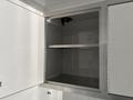 An empty storage compartment with metal shelves inside a white vehicle