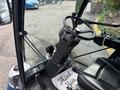 The interior of a 2019 Madvac LS175 street sweeper featuring a steering wheel controls and seat with a floor mat that says thank you