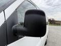 A white 2004 Chevrolet Express van with a focus on the side mirror