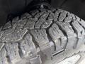 A close-up of a textured tire tread on a vehicle showcasing deep grooves and rugged patterns designed for traction and off-road performance