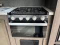 A Furrion stove and oven combo featuring a black grate with four control knobs and a sleek silver door beneath the cooking surface