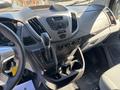 Interior dashboard of a 2016 Ford Transit 150 featuring a gear shift, control panel, and cup holders