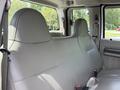 Interior view of a 2008 Ford F-250 SD with gray leather bench seats in the back row and seatbelts on either side