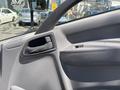 Interior view of a 2016 Isuzu NPR-HD door panel featuring a control handle and buttons in a textured gray finish