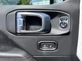 Close-up of the door handle and power window controls in a 2021 Jeep Wrangler interior