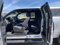 A 2014 Ford F-150 with an open driver's door and passenger door exposing the interior featuring black seats and dashboard controls