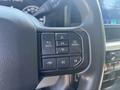 A steering wheel control panel featuring buttons for back, OK, menu, phone, and media navigation in a 2023 Ford F-350 SD