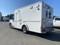 A white 2011 Chevrolet Express ambulance with emergency markings on the side and a rear compartment for medical equipment and personnel access