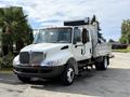 A 2012 International 4300 truck with a white and silver exterior featuring a flatbed and a box on the back