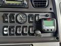 Dashboard controls of a 2015 Freightliner M2 featuring various switches a pressure gauge and a digital display unit