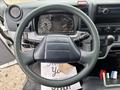 The image shows the steering wheel and dashboard of a 2015 Mitsubishi Fuso FE160 with various gauges and controls visible