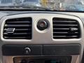 Dash controls of a 2011 Chevrolet Colorado featuring air vents a hazard light button and display for time and temperature