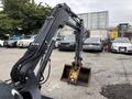 A 2017 John Deere 50G excavator with a front bucket and hydraulic arm positioned for digging