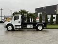A 2019 Freightliner M2 truck with a flatbed design is shown in profile with a white cab and black chassis