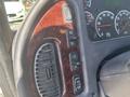 Dashboard controls of a 2022 Freightliner M2 106 including buttons for cruise control and air conditioning on a wood grain trim