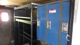 A 2004 Freightliner MT45 interior featuring metal lockers with blue doors and shelving units designed for storage