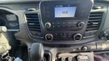 The dashboard of a 2021 Ford Transit featuring a touch screen display controls for temperature and audio along with gear shift and ignition key area