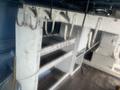 A 2009 Ford Econoline interior featuring white shelving units with metal hooks and support brackets designed for storage and organization