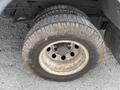 A close-up view of a dirty wheel on a 2011 Ford Econoline with visible tire tread and wear on the rim