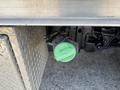 A green diesel fuel cap attached to a 2020 Chevrolet Silverado truck with a metal surface in the foreground