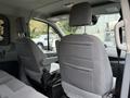 Interior view of a 2018 Ford Transit featuring two gray front seats with headrests and armrests