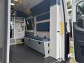 Interior of a 2020 Mercedes-Benz Sprinter 2500 showing seating and storage compartments with blue padding and grey surfaces