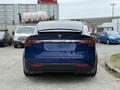 A blue 2020 Tesla Model X viewed from the rear showcasing its sleek design and rear taillights