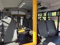 Interior of a 2016 Ford Econoline with grey seats and a yellow support pole in the center