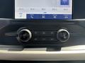Close-up of a 2021 Ford F-150 dashboard control panel featuring audio volume and tuning knobs with a digital display screen above