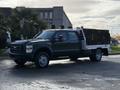 A black 2008 Ford F-550 truck with a white flatbed and toolboxes mounted on the sides