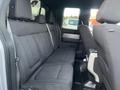 Interior view of the back seat of a 2014 Ford F-150 featuring black cloth upholstery and adjustable headrests