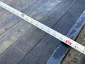 A 2020 Ford F-350 with a measuring tape laid across the wooden surface of a truck bed