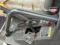 Close-up of the control lever and dashboard of a 2011 Kubota RTV 1140 CPX featuring various buttons and safety warnings