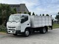 A white 2014 Mitsubishi Fuso FE truck with a flatbed and side panels is parked on a concrete surface