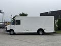 A white 2012 Ford E-450 Super Duty box truck with a side door and no visible markings stands parked on a concrete surface