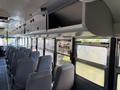 Interior of a 2009 International 3000 CE school bus featuring grey seating and overhead storage compartments