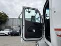 The open door of a 2025 Peterbilt 536 revealing the interior with a black panel and window visible