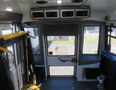 Interior view of a 2020 Chevrolet Express showing the front dashboard and emergency door with bilingual signage