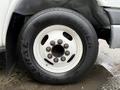 Close-up of a black General Grabber tire mounted on a white rim with eight bolt holes on a 2015 Chevrolet Express