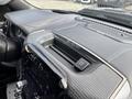 A close-up view of the dashboard of a 2021 RAM 1500 showcasing its controls and features with a digital display and textured surfaces