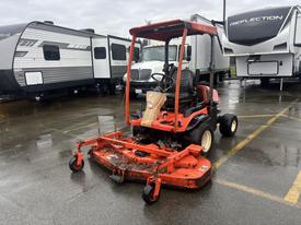A red 2010 Kubota F3680 lawn mower with a mounted mower deck and an open cab for the driver