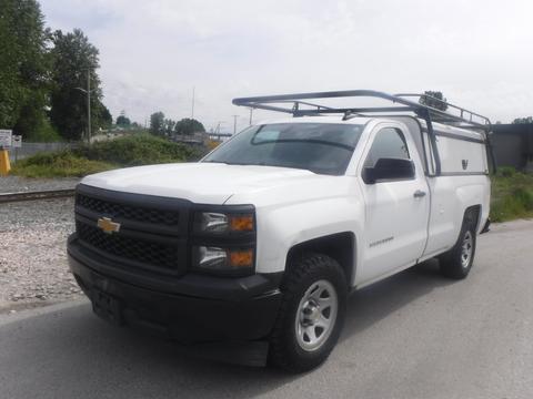 White 2015 Chevrolet Silverado 1500 with a black grille and a roof rack parked on a road