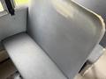 A gray vinyl seat from a 2013 International 4300 bus with a flat back and cushion seat