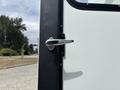 Close-up of a chrome door handle on a 1994 GMC Vandura 3500 with a white and black exterior