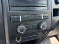 Dashboard controls of a 2014 Ford F-150 featuring air conditioning knobs and buttons for climate control