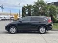 A black 2014 Honda CR-V parked with a side view showcasing its sleek design and alloy wheels